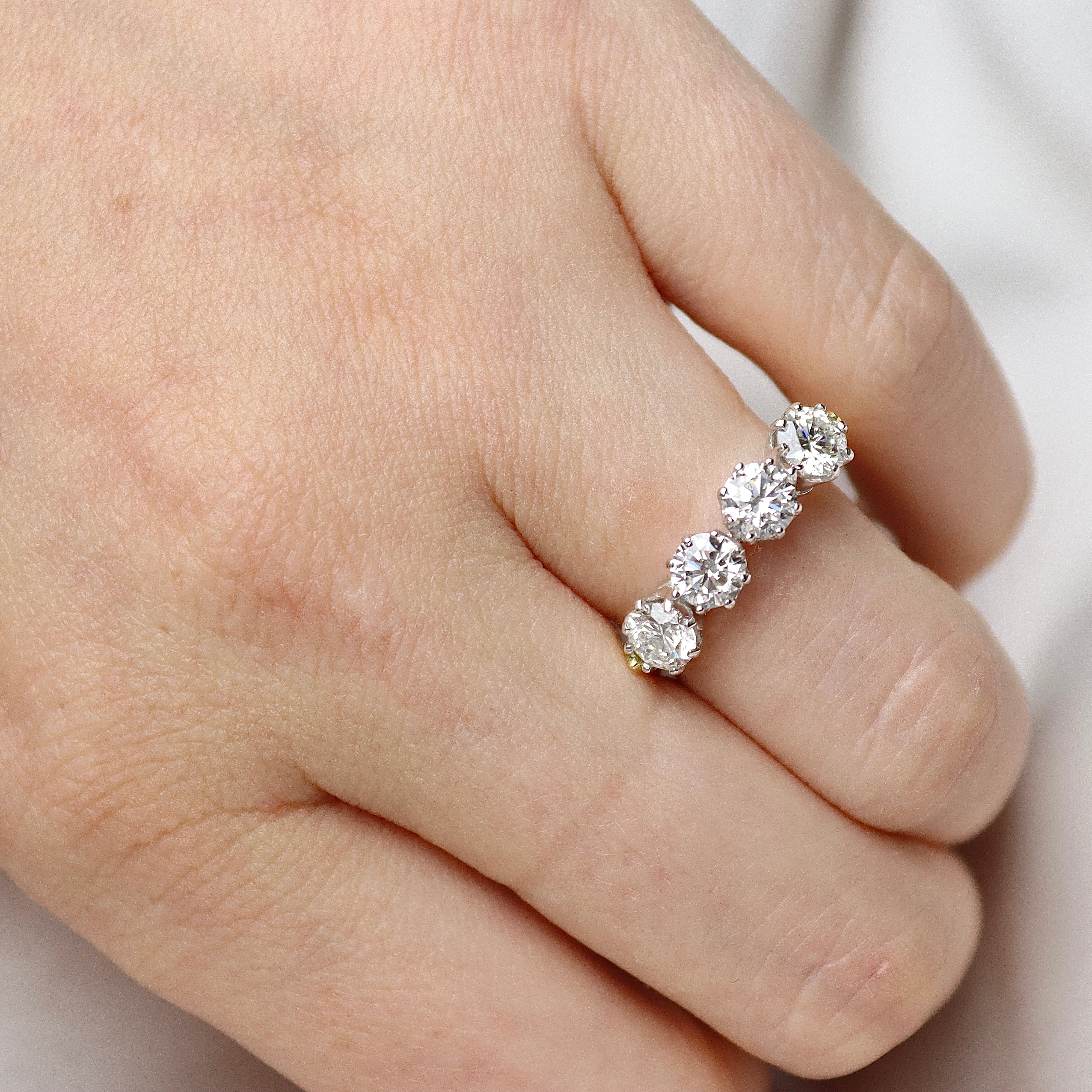 Close view of an 18ct two-tone gold four stone lab-grown diamond ring with a 5.6 mm top