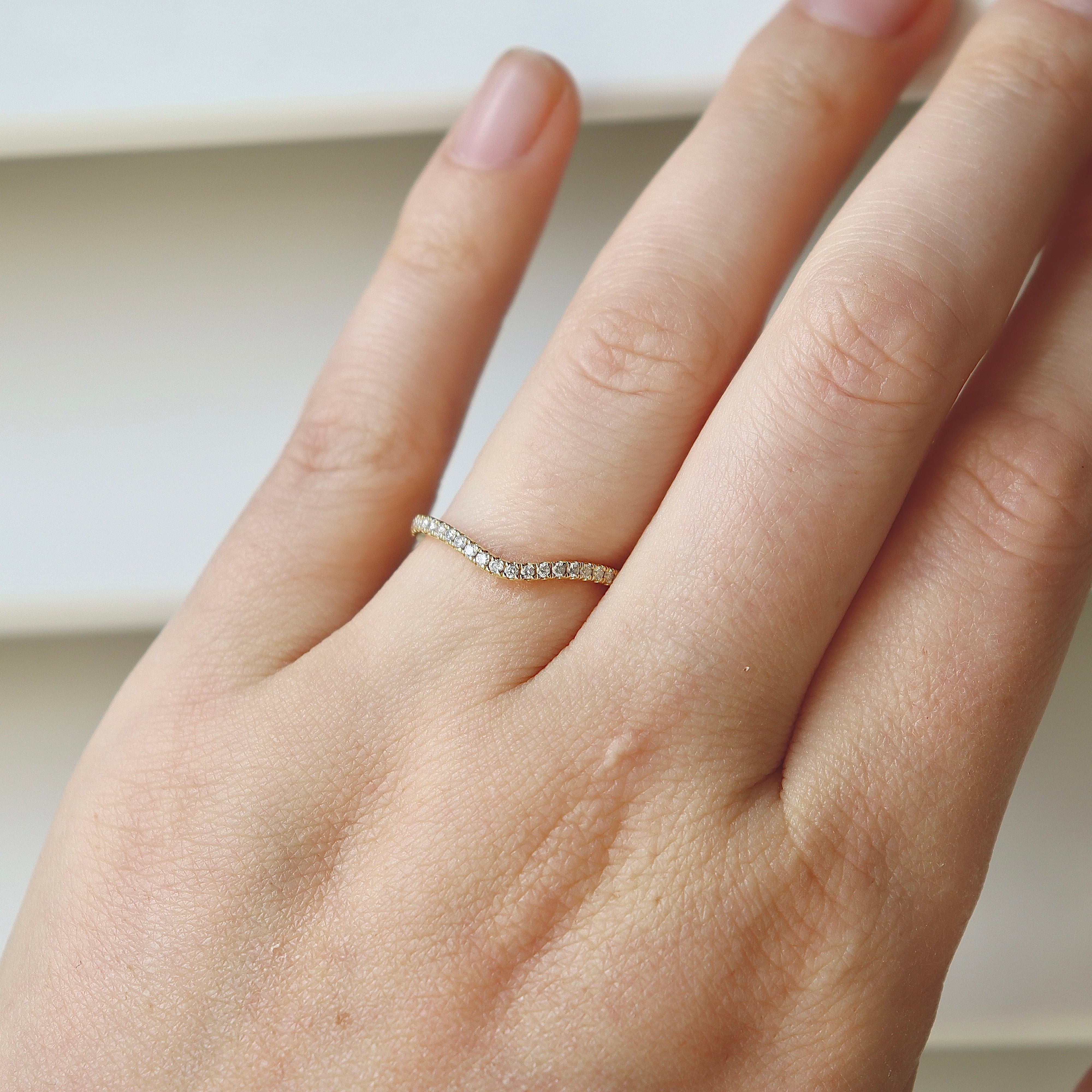 Close-up of the .25ct diamond detailing across an 18ct yellow gold curved band ring