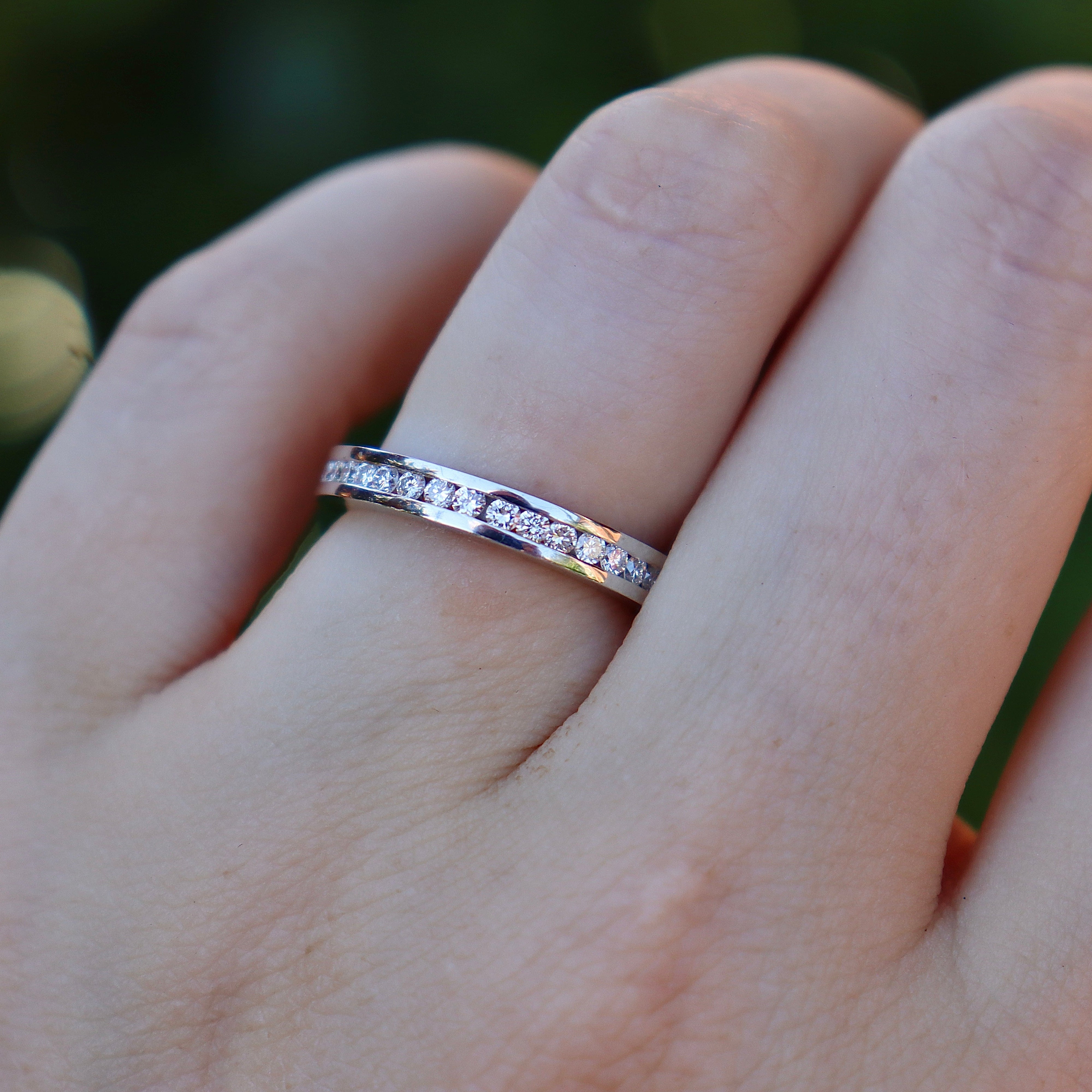 Platinum diamond wedding band displayed upright with a clean channel setting and bright stones