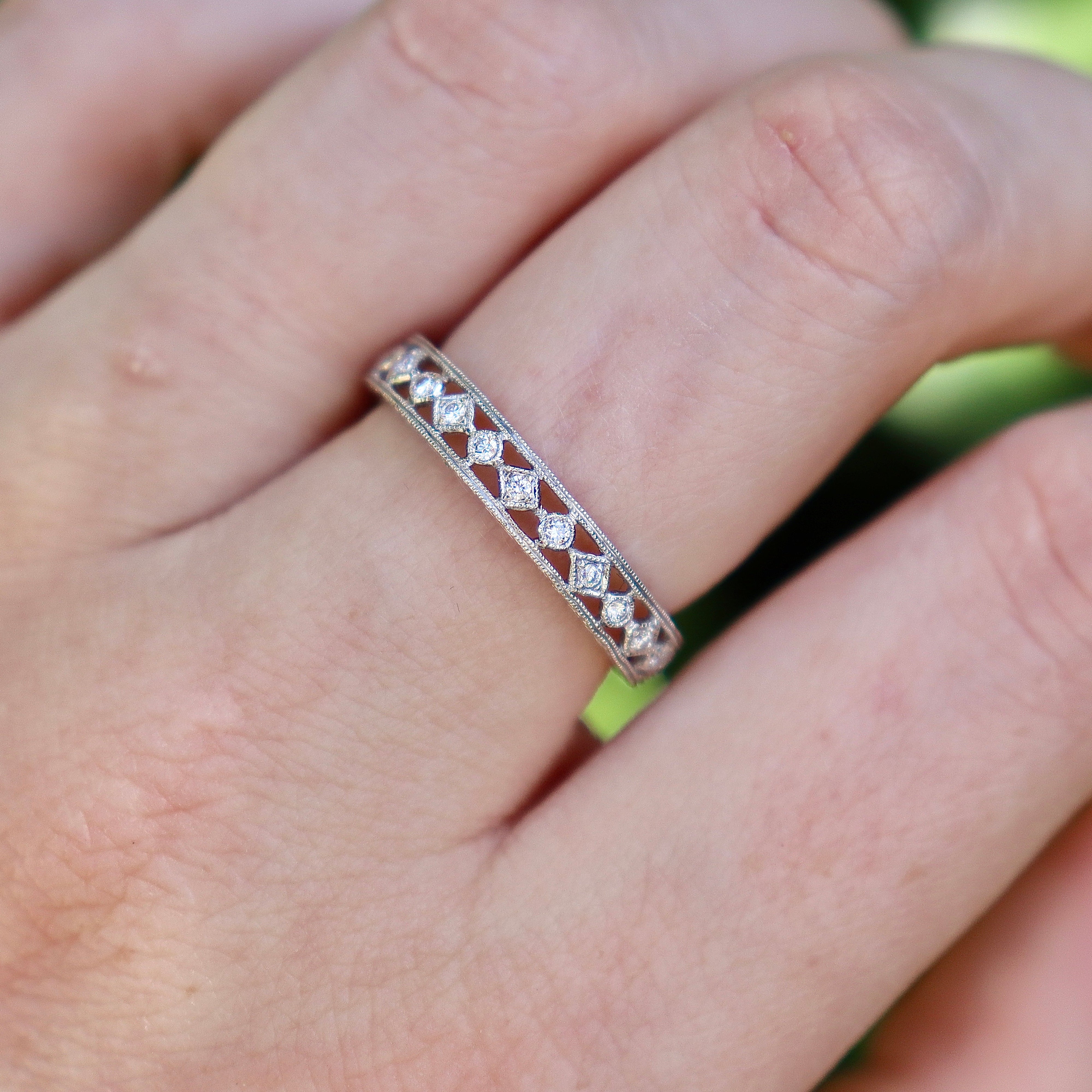 Close view of an 18ct white gold pierced-out diamond wedding band showing its openwork detail