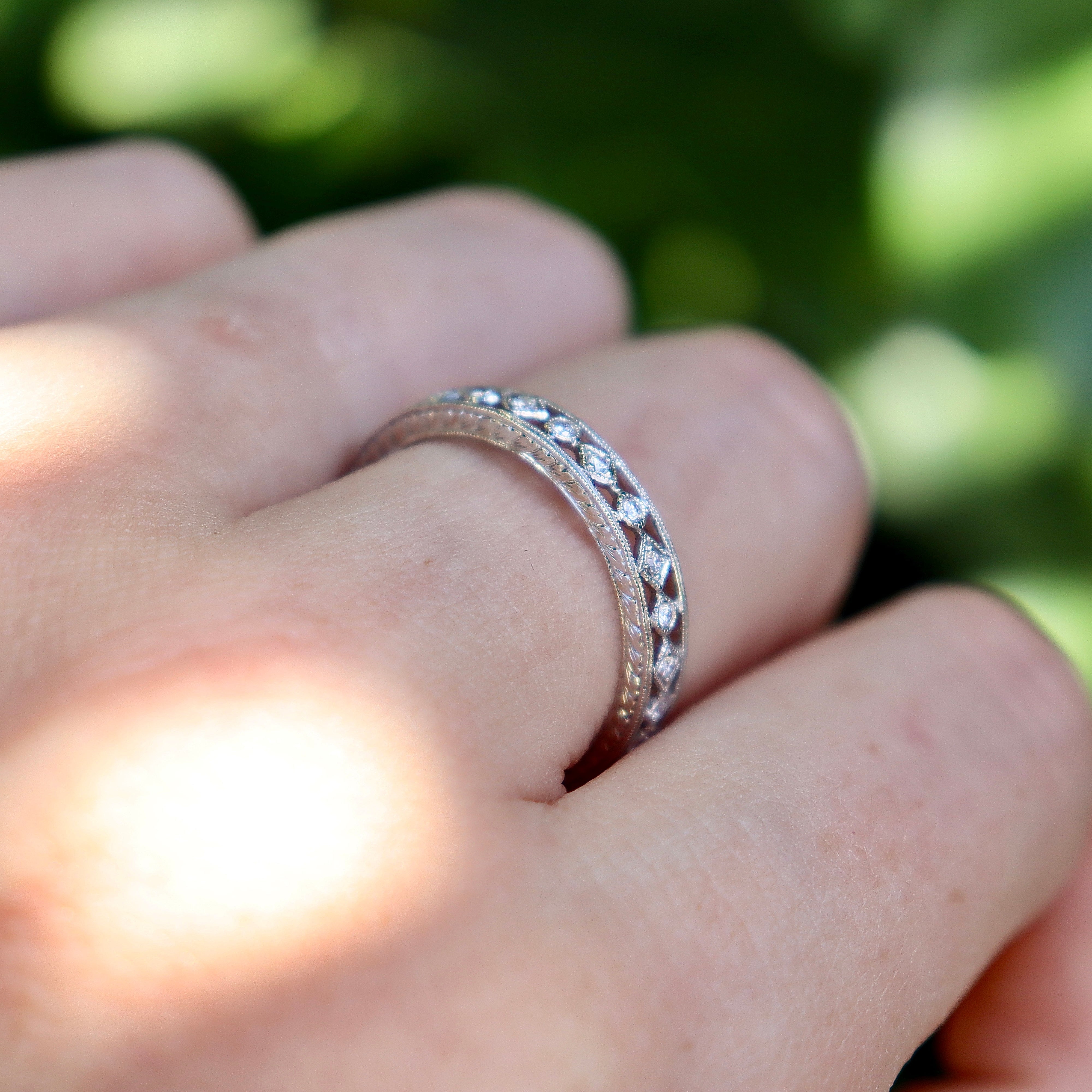 18ct white gold vintage-style diamond wedding band displayed upright with delicate pierced-out design