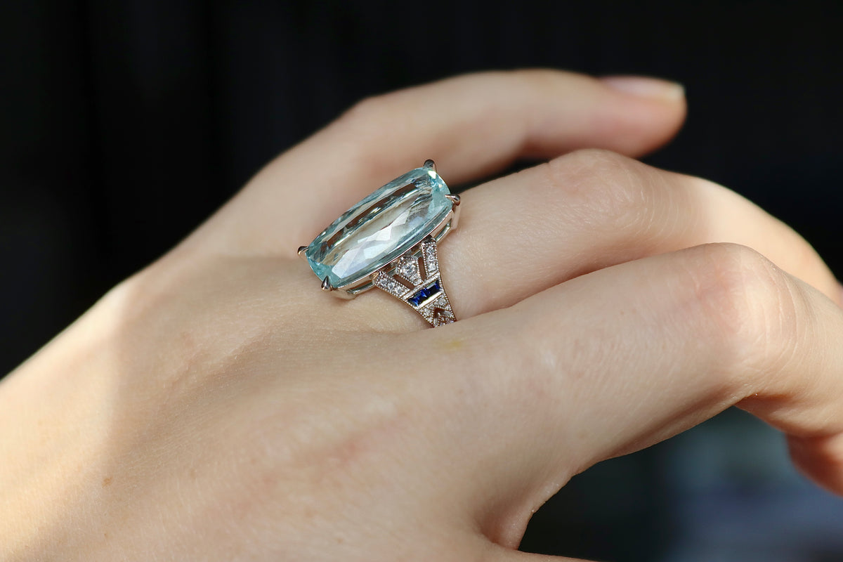 Anillo estilo Art Déco de aguamarina, zafiros y diamantes en oro blanco de 18 quilates