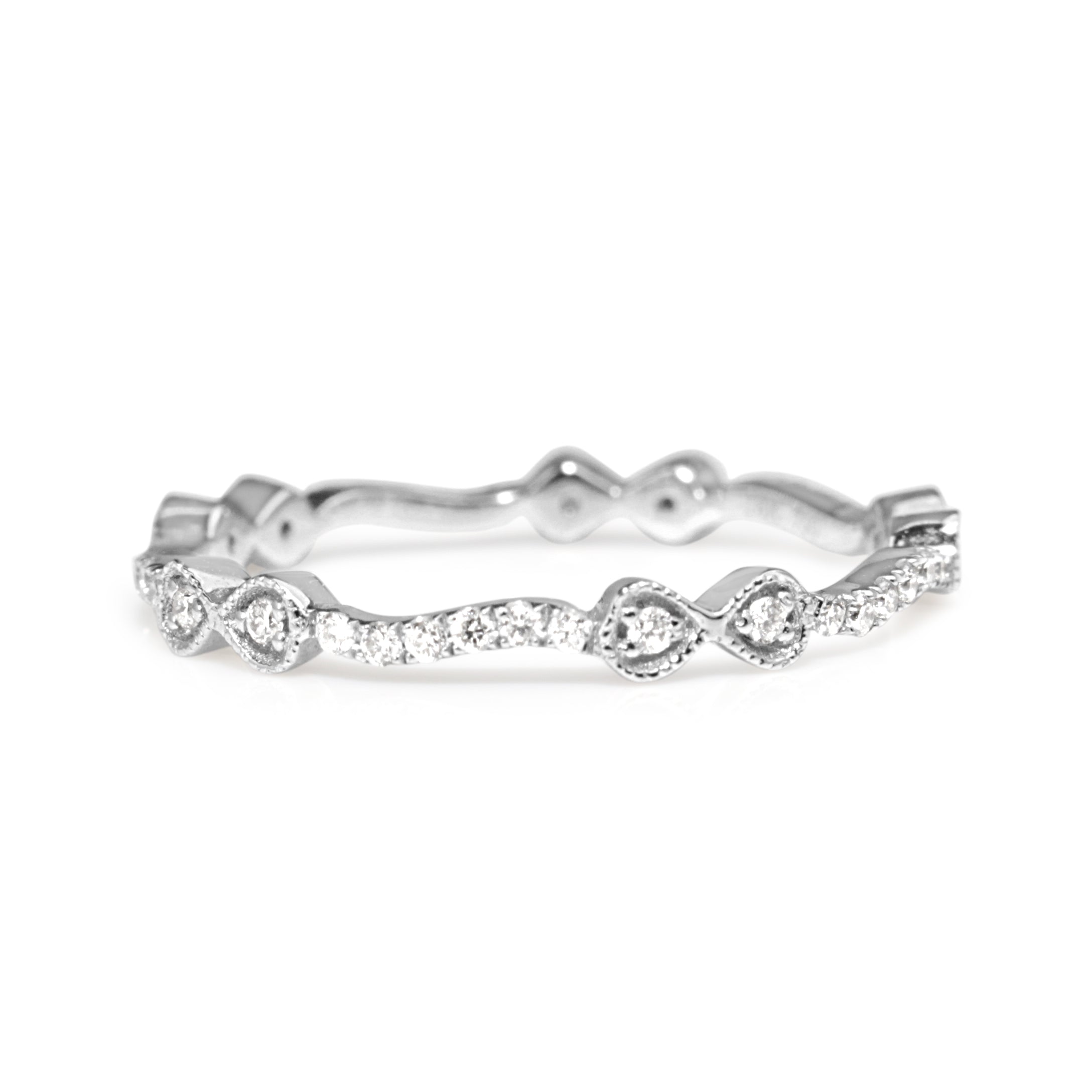 Angled view of white gold all round diamond band with bow-shaped details
