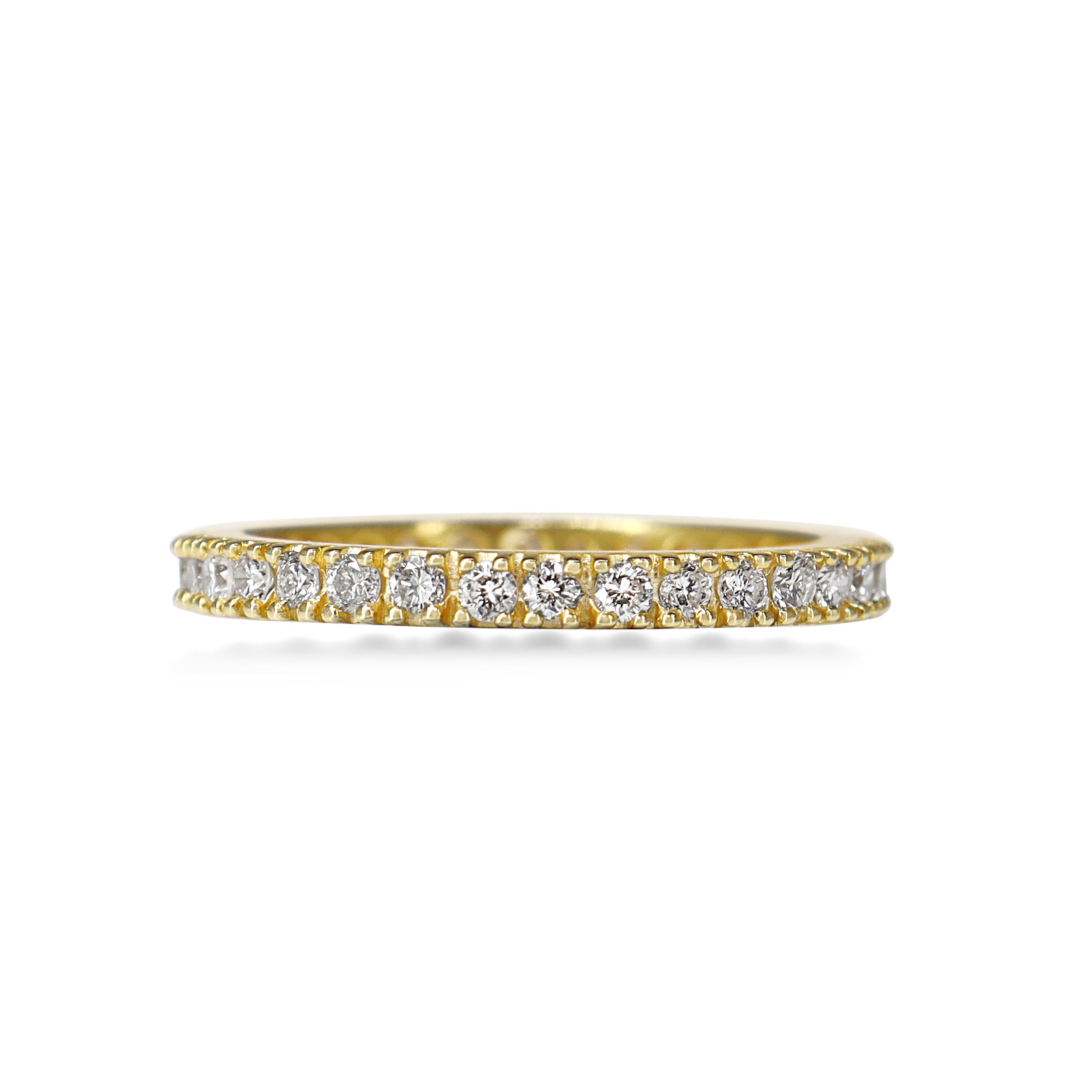 Close-up of G colour Si clarity diamonds in yellow gold wedding band