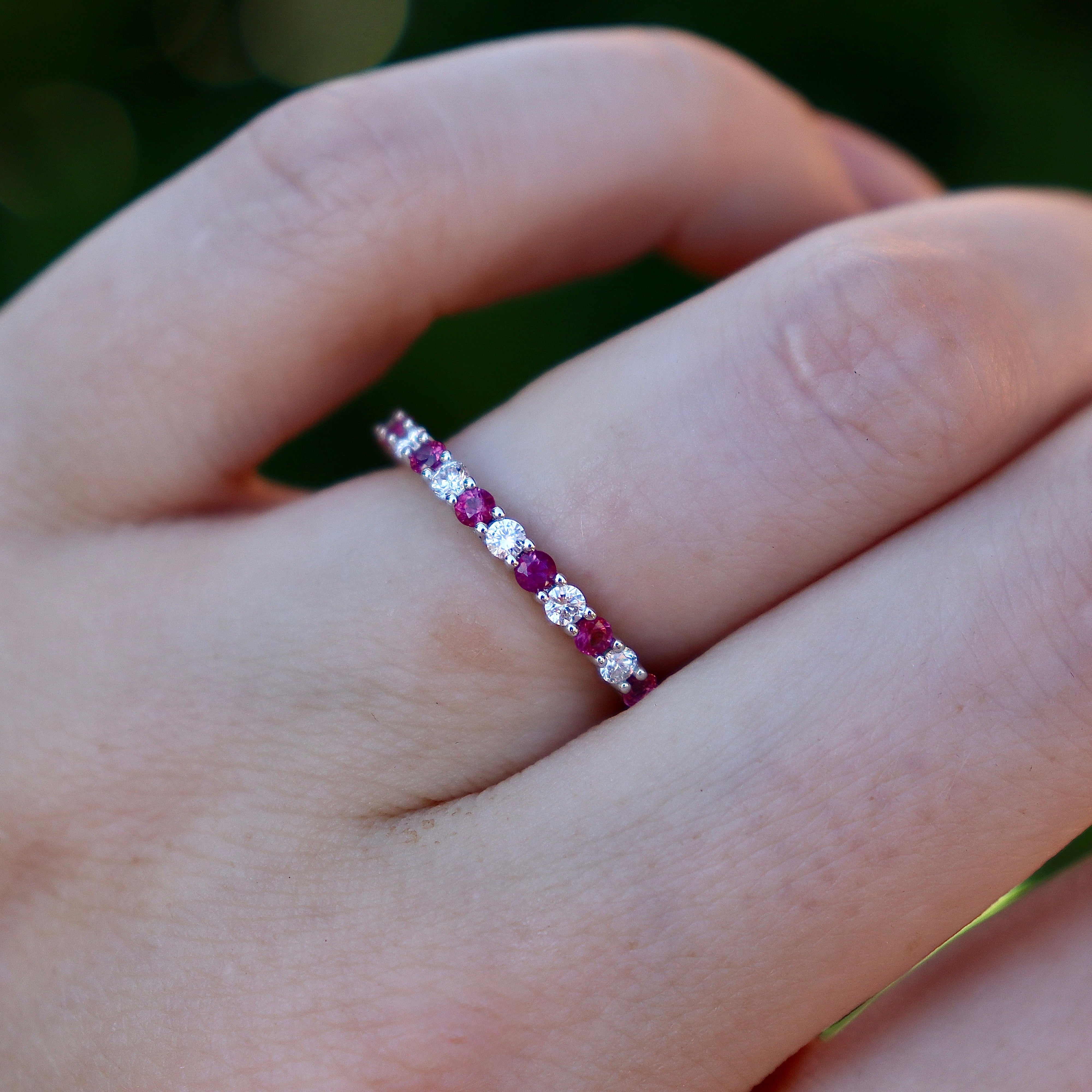 Angled view of the ruby and diamond 3/4 eternity band showing its fine 2mm white gold profile