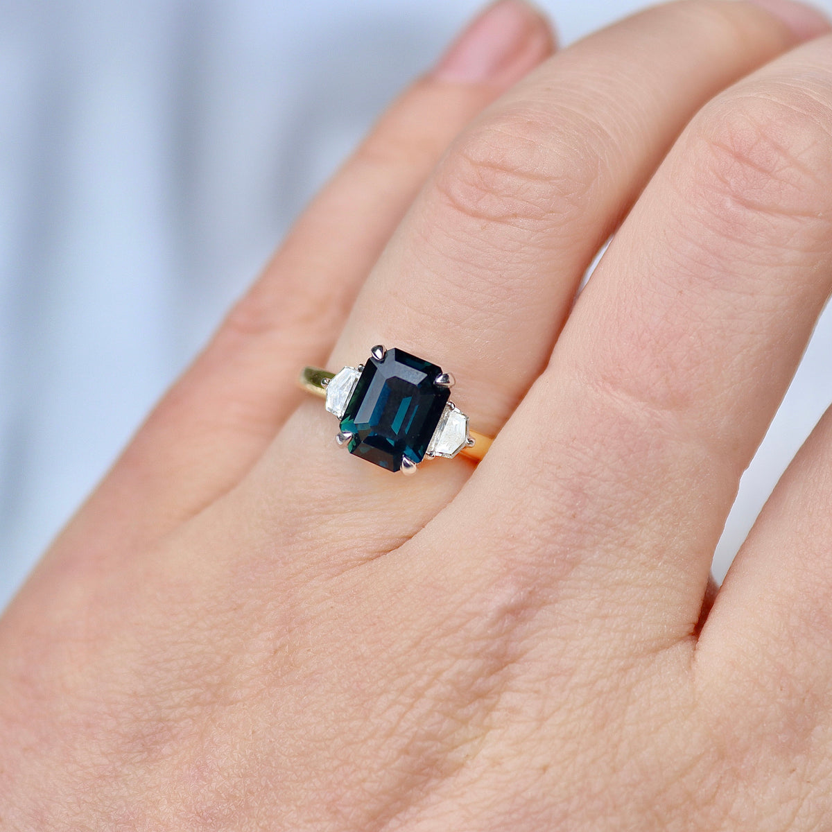 18ct Yellow and White Gold Emerald Cut Teal Sapphire and Cadillac Diamond 3 Stone Ring