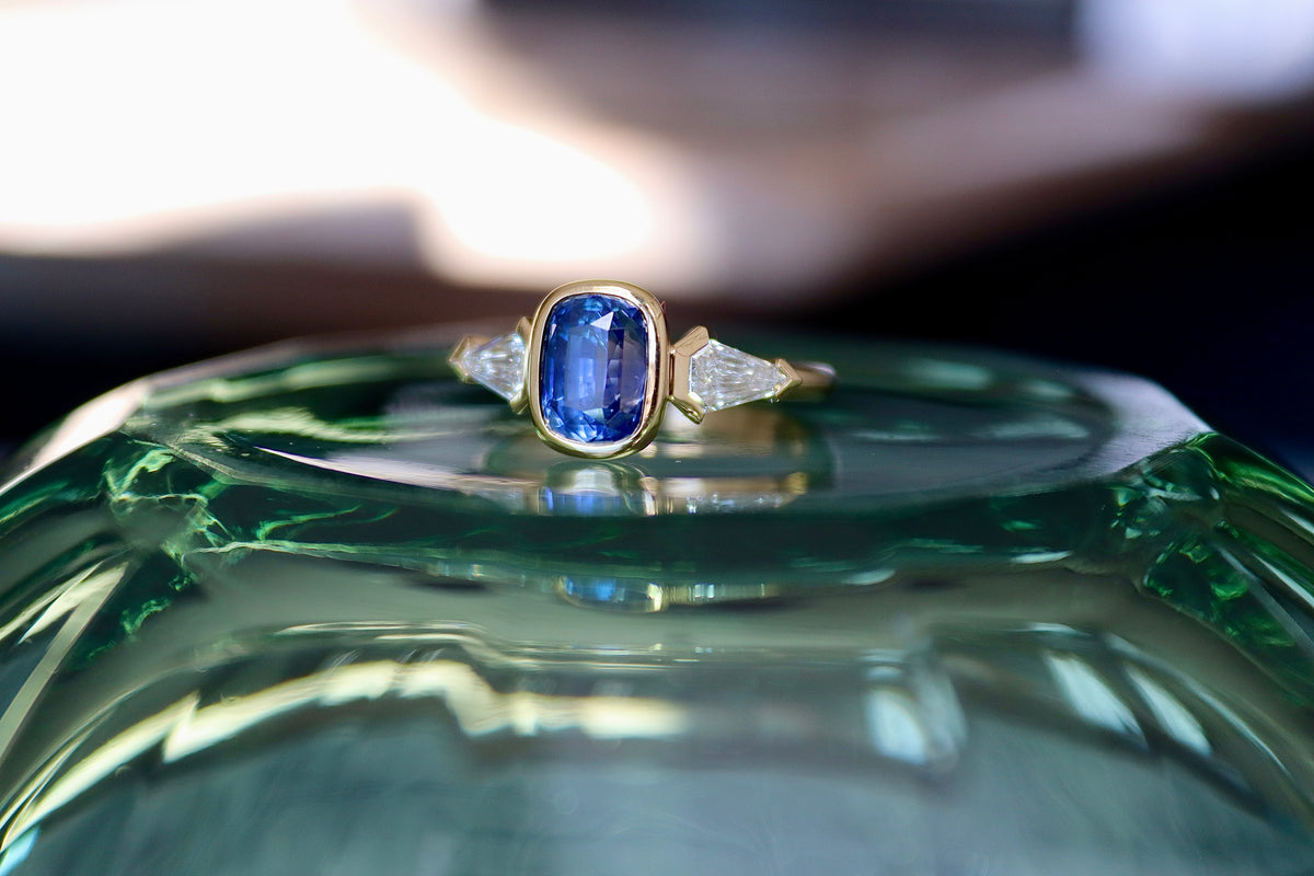 Anillo de tres piedras de oro amarillo de 18 quilates con zafiro y diamantes talla escudo