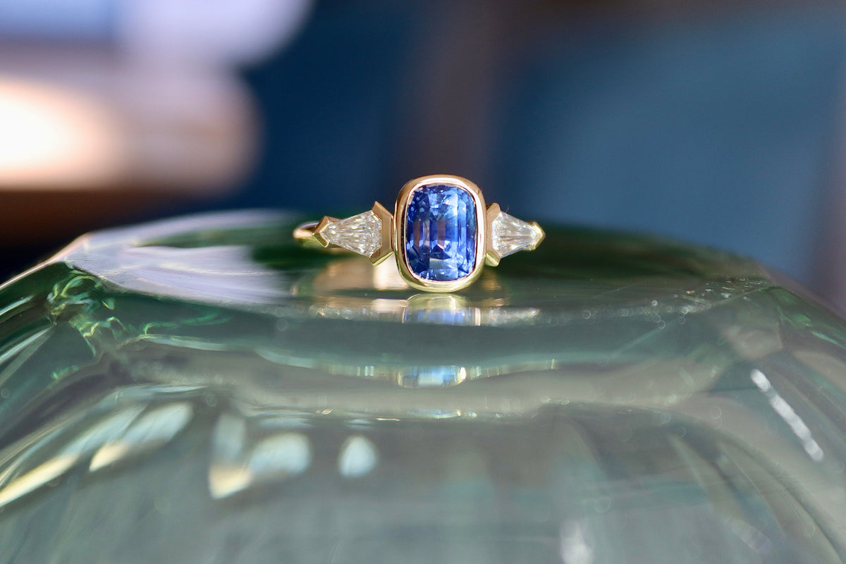 Anillo de tres piedras de oro amarillo de 18 quilates con zafiro y diamantes talla escudo