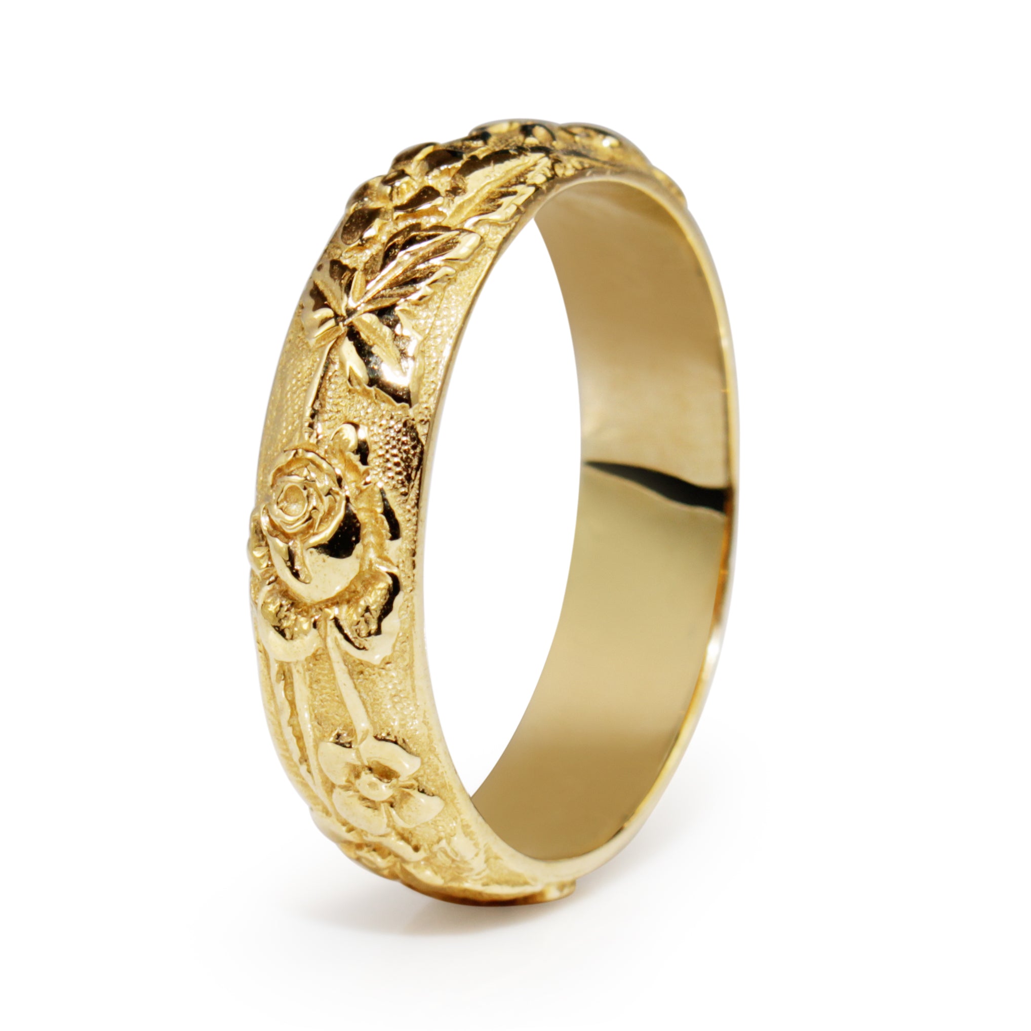 Angled view of 9ct yellow gold floral engraved band showing the patterned exterior and smooth interior